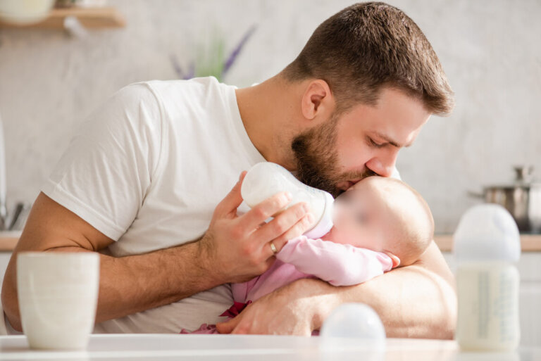 père donnant le biberon à son bébé